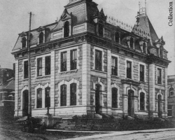 Le bureau de poste de Sherbrooke, vers 1905. Construit en 1885, il garde cette fonction jusqu’en 1953 et devient alors la bibliothèque municipale. Au moment de sa construction, le courrier est transporté par train, mais avant l’arrivée du chemin de fer ce sont des diligences qui assurent ce service à partir de Québec ou de Boston.