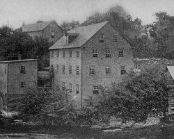 La compagnie <em>Magog Woollen Mills</em>, sur la rivière Magog, vers 1898. Établie par A.L. Grindrod en 1868, elle devient ensuite la propriété de la famille Lomas jusqu’à sa fermeture en 1924.