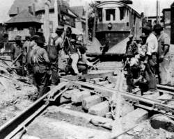 Des travaux sont effectués sur une ligne de tramway, là où les rails du Canadien Pacifique croisent la rue Alexandre, vers 1920. Ces travaux sont probablement effectués dans le cadre de la construction de la ligne Fairmount, qui se rend dans le quartier Ouest.