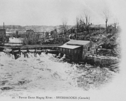 La rivière Magog et le barrage no 2, vers 1900. Dans le bâtiment situé à droite de la photographie se trouve la station de pompage, où l’eau est puisée dans la rivière avant d’être distribuée par le réseau d’aqueduc de Sherbrooke. Beaucoup se plaignent de son mauvais goût, causé par la pollution de la rivière...