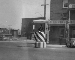 Un policier dirige la circulation au coin des rues King Ouest et Grandes-Fourches, vers 1957. Malgré la présence de feux de circulation depuis 1930, ces policiers restent présents sur certains carrefours routiers de Sherbrooke jusque dans les années 1970.