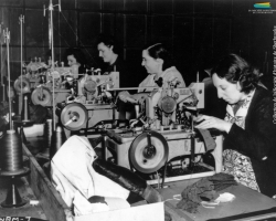 Des femmes travaillent à la confection d’uniformes, pendant la Seconde Guerre mondiale (1939-1945). À Sherbrooke, les manufactures de tissus (Paton, Dominion Textile) et de vêtements (S. Rubin Ltd) reçoivent de telles commandes du gouvernement canadien.