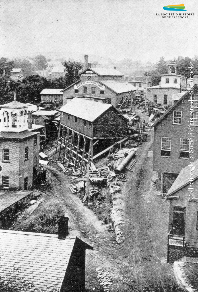 La Jenckes Machine Company (à l’arrière, au centre de la photo), située entre la rue Bank et la rivière Magog, en 1890. À l’origine installée sur la rue <em>Factory</em> (Frontenac), la compagnie emménage sur ce site en 1887.