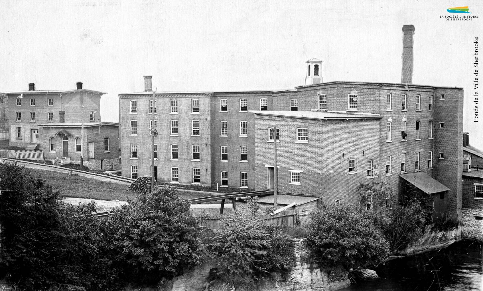 Vue de l’arrière des bâtiments de la manufacture de laine d’Adam G. Lomas, située entre la rue Belvédère Nord et la rivière Magog, en 1898.