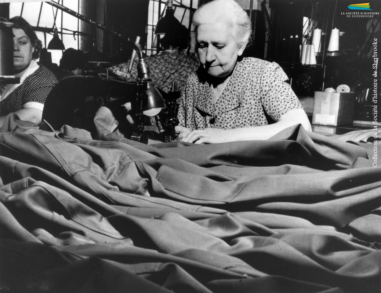 Des femmes travaillent à la confection d’uniformes, pendant la Seconde Guerre mondiale (1939-1945). À Sherbrooke, les manufactures de tissus (Paton, Dominion Textile) et de vêtements (S. Rubin Ltd) reçoivent de telles commandes du gouvernement canadien.