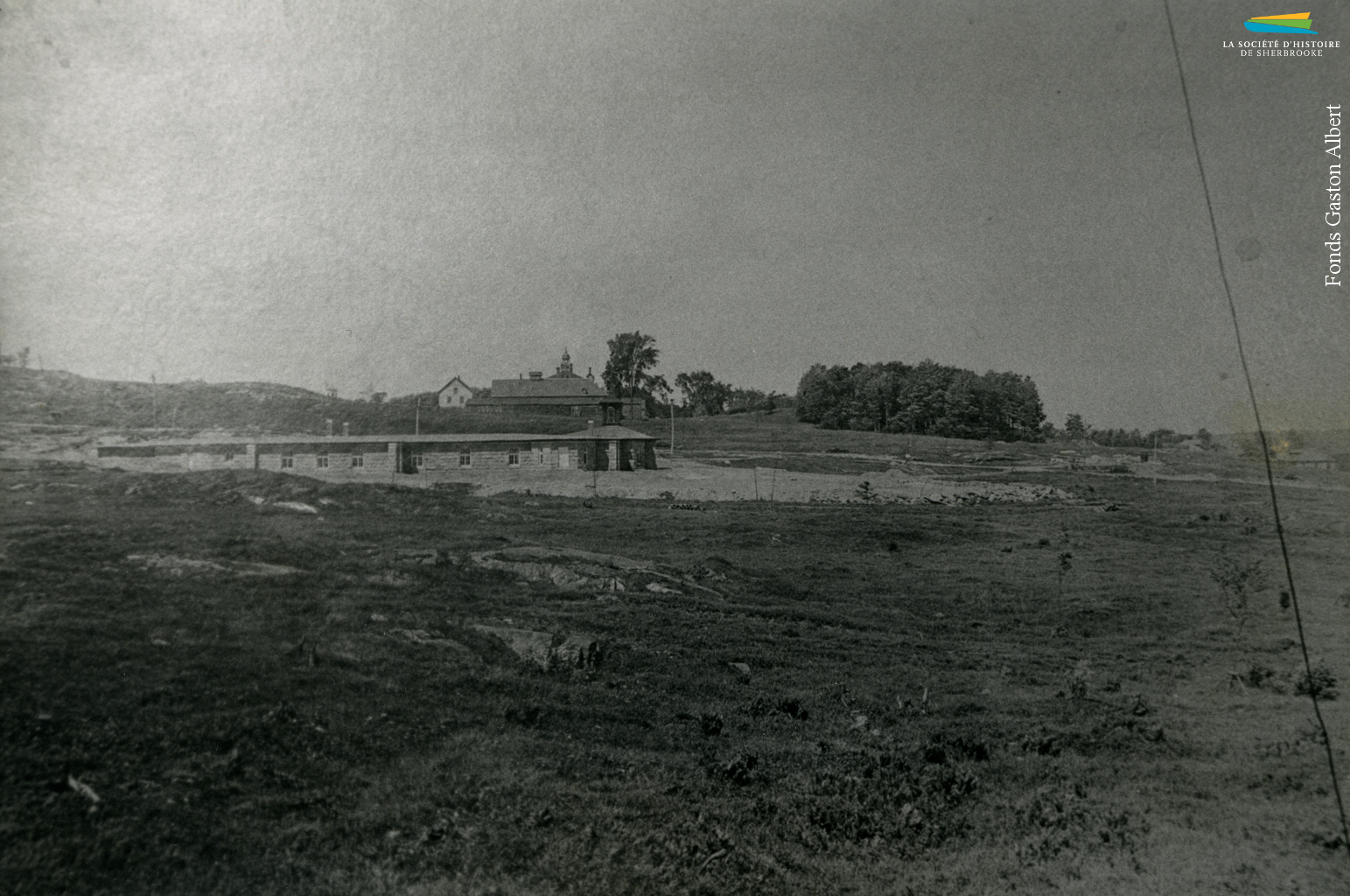 La construction de l’église Immaculée-Conception, vers 1910. C’est la Sherbrooke Real Estate Co. qui fait don en 1908 du terrain où l’église est construite. La compagnie immobilière veut construire un nouveau quartier et y attirer des ouvriers canadiens-français, ce pourquoi une église est construite au beau milieu d’un champ. Les rues environnantes (dont la rue LaRocque et la rue Adélard-Colette) et les logements sont tracés et construits dans les années suivantes.