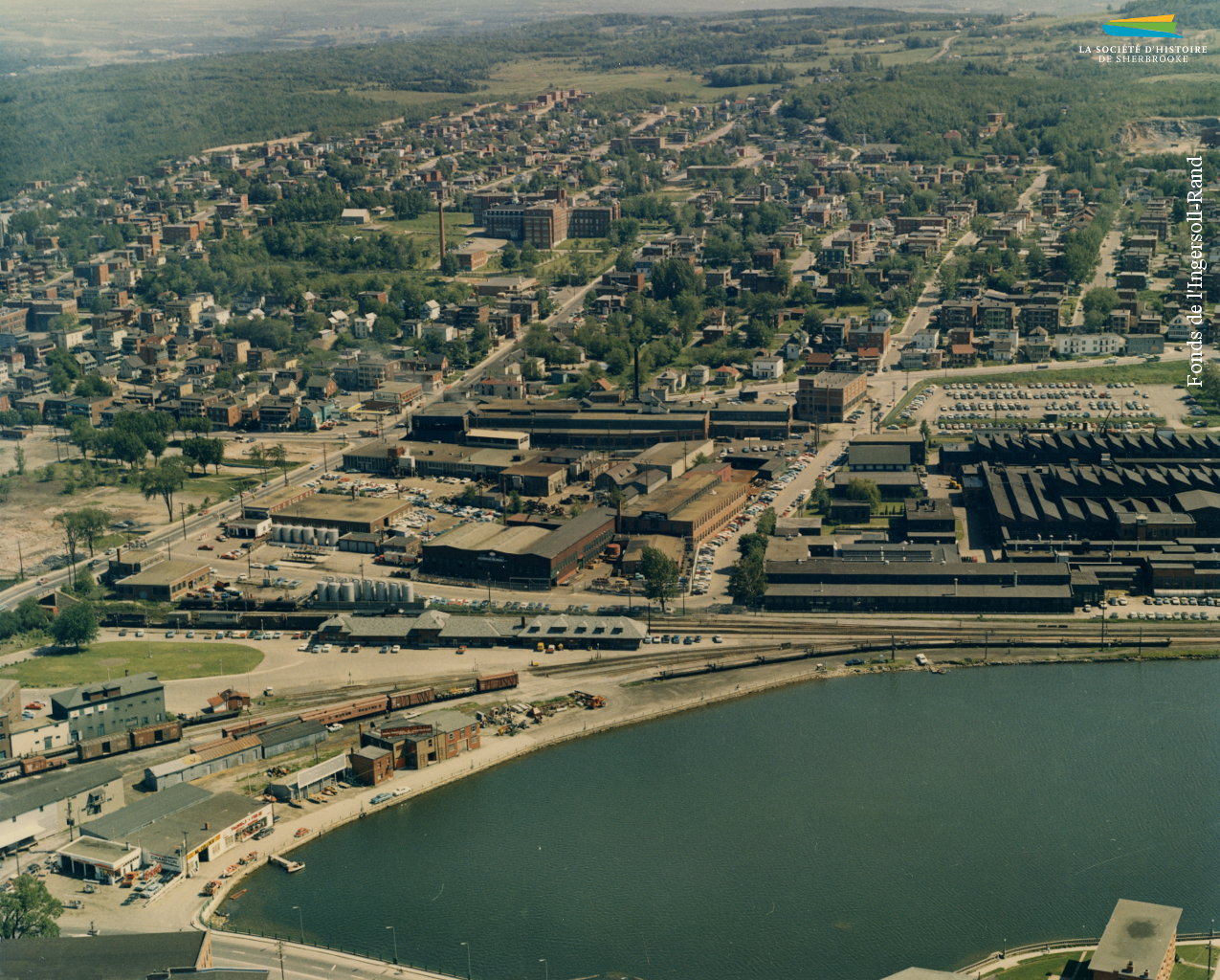 Vue aérienne du quartier Ouest en 1963. À l’avant-plan se trouvent les usines métallurgiques et la gare du Canadien Pacifique avec, derrière, les rues résidentielles.