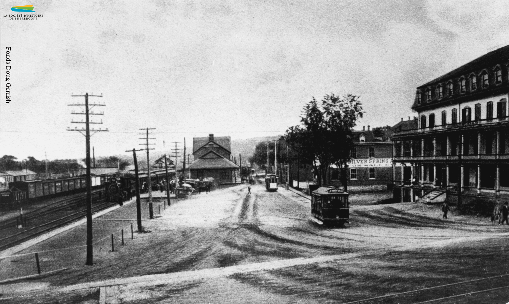 La rue <em>Depot</em> (du Dépôt) en 1897 ou 1898. La gare Union se trouve sur le site de la première gare de Sherbrooke, construite pour accueillir le premier train en 1852. La rue est aussi le centre du réseau de tramway de la ville, les visiteurs arrivant systématiquement en train.