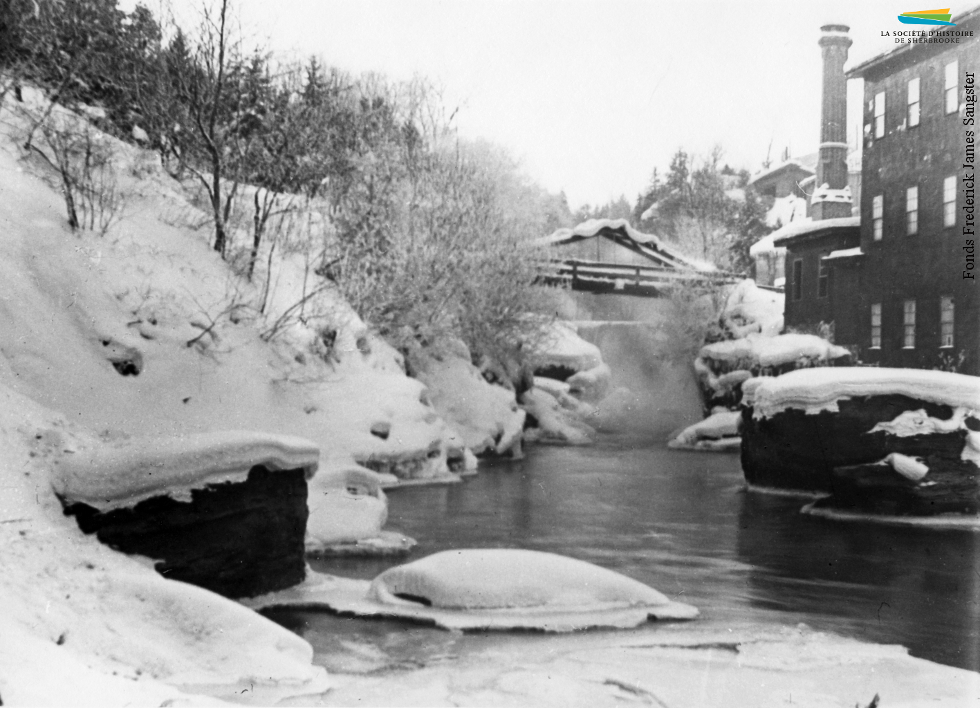 La rivière Magog en hiver, vers 1900. Son fort débit fait en sorte que l’eau ne gèle pas et qu’elle peut alimenter en énergie hydraulique les manufactures situées sur ses rives. Après l’adoption de l’électricité comme principale source d’énergie, ce sont les centrales hydroélectriques qui sont alimentées toute l’année.