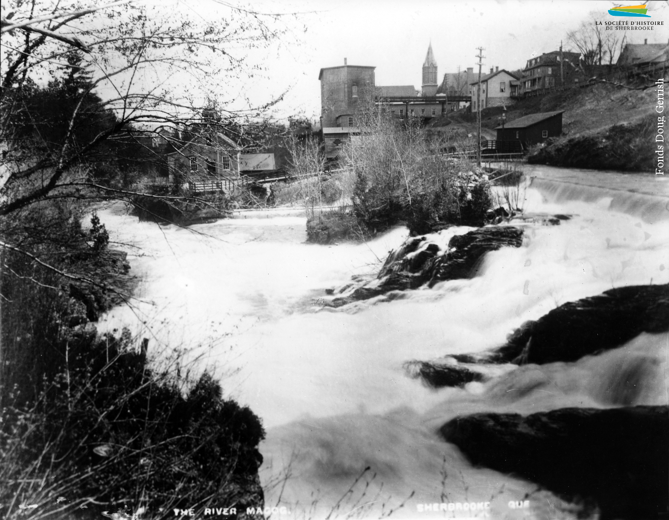 La rivière Magog et la centrale Frontenac (le bâtiment à gauche), vers 1896. Le barrage no 3, hors champs, sert à approvisionner en eau les moulins et manufactures situés à proximité. Il est converti en 1888 pour produire de l’électricité, une source d’énergie adoptée progressivement par les manufactures de Sherbrooke. L’eau sert encore de source d’énergie pendant quelques décennies.